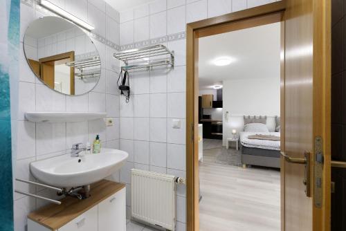 a bathroom with a sink and a mirror and a bedroom at Albgängerle in Mössingen