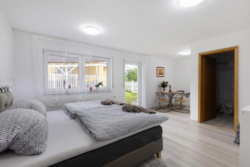a white bedroom with a bed and a window at Albgängerle in Mössingen