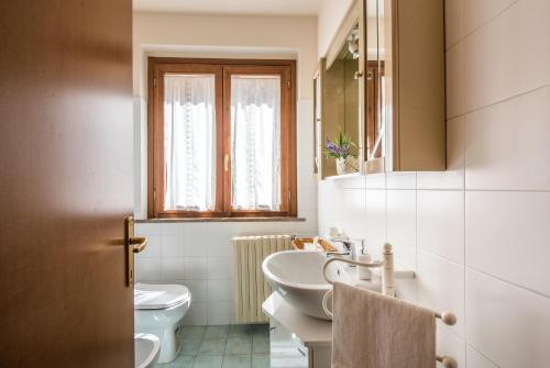 a white bathroom with a sink and a toilet at Casa Vacanze Chianti Summer in Gaiole in Chianti