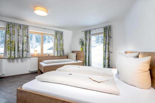 a bedroom with two beds and two windows at Haus Sabrina Hexenkopf in See