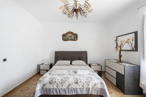 a bedroom with a large bed and a chandelier at Holidayshouse in Ercolano