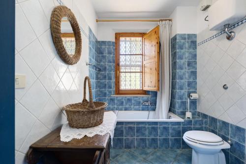 a blue tiled bathroom with a toilet and a window at La Ripa - Appartamento Padronale in San Gimignano