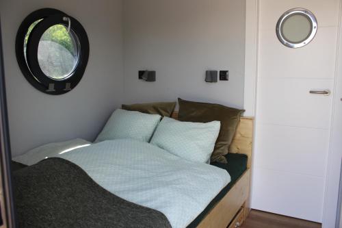 a bed in a small room with a window at Hausboot Schwanennest in Kirchberg an der Raab