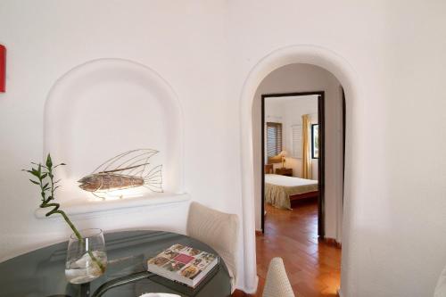 a room with a table with a bug on the wall at Apartamento Vila Mourisca in Porches