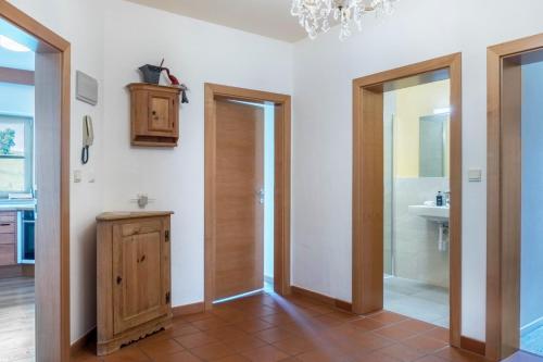 a bathroom with two doors and a sink and a mirror at Rotkäppchen Schlosshof in Völs am Schlern