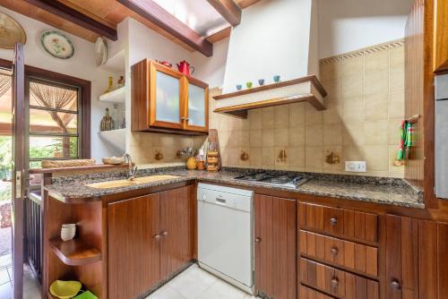 a kitchen with wooden cabinets and a sink at Villa Can Sol in Pollença