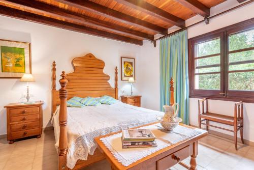 a bedroom with a large bed and a table at Villa Can Sol in Pollença