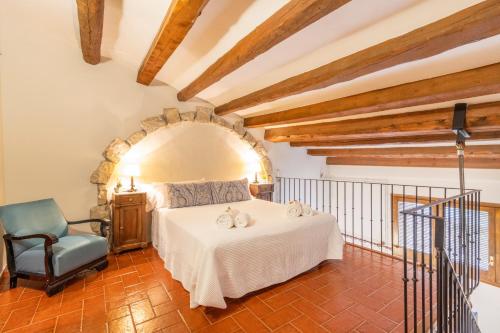 a bedroom with a white bed and a blue chair at Cal Comorera in Masoteras