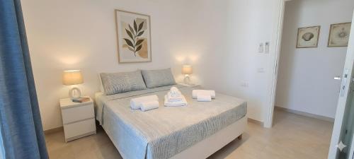 a bedroom with a bed with two towels on it at C 210 Puntavilla in La Maddalena