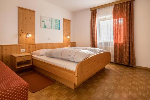 a bedroom with a large wooden bed in front of a window at Apartment Pustertal in Mühlbach