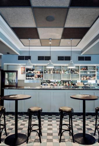 a restaurant with two tables and chairs in front of a counter at The North Sydney Hotel in Sydney
