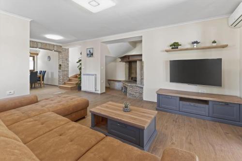 a living room with a couch and a flat screen tv at Holiday Home Pahari by Rent Istria in Roč