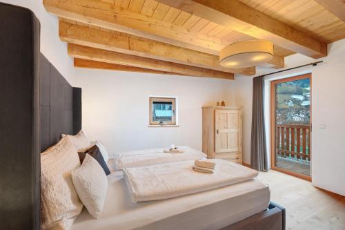 a bedroom with a bed and a large window at Alpin Chalet Samer in Sarntal