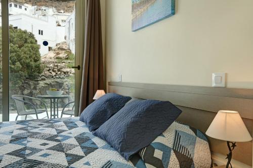 a bedroom with a bed and a balcony with a table at Albamar 1d in Puerto de Mogán