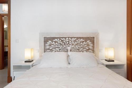 a bedroom with a large white bed with two lamps at Alpispa in Arrecife