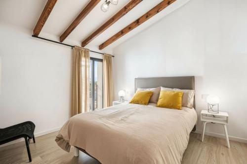 a white bedroom with a large bed with yellow pillows at Mirasol in Benitachell