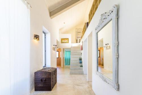 a mirror in a hallway with a wicker stool at Espaço Fataca - Sw Alentejano in São Teotónio