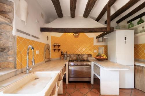 a large kitchen with wooden counters and a white refrigerator at La Isla Verde in Els Hostalets