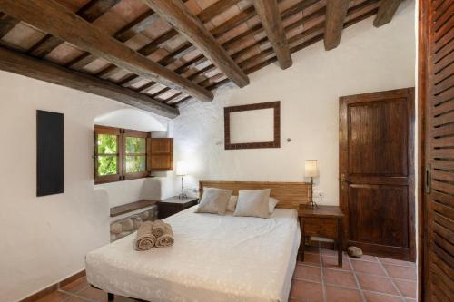 a bedroom with a bed in a room with wooden ceilings at La Isla Verde in Els Hostalets