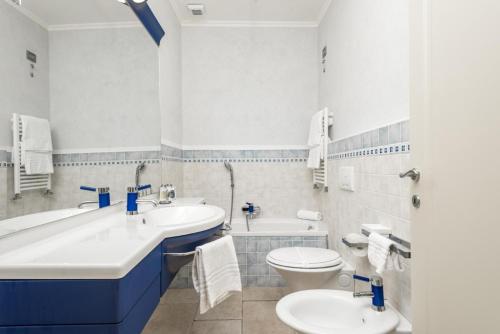 a bathroom with two sinks and a tub and a toilet at Orizzonte Damare in Volastra