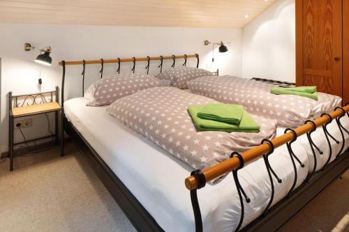a bedroom with a large bed with green towels on it at Feldbergstern in Feldberg