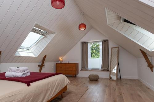a attic bedroom with a bed and two windows at Ker Mam - Belle-Ile in Sauzon