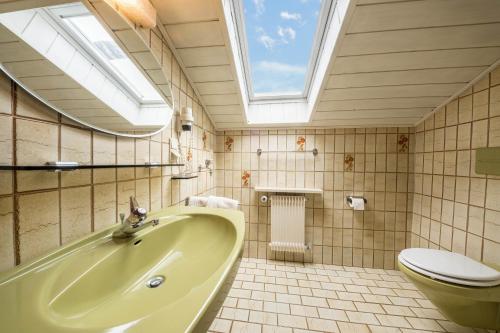 a bathroom with a sink and a toilet and a skylight at Residence Kronstein - Fewo 8 in Tesimo