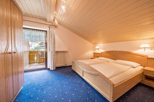 a bedroom with a large bed and a window at Residence Kronstein - Fewo 8 in Tesimo