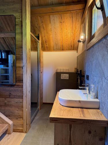 a bathroom with a white sink on a wooden counter at Mazot de la Pointe Percée in Combloux