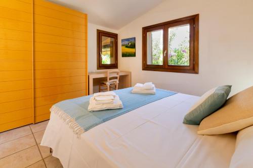 a bedroom with a large bed with towels on it at Villa Amalthea - sea view-wellness in Costa Paradiso