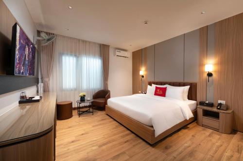 a bedroom with a large white bed with a red pillow at Lam Anh Hotel 10 Ngoai Giao Doan in Hanoi