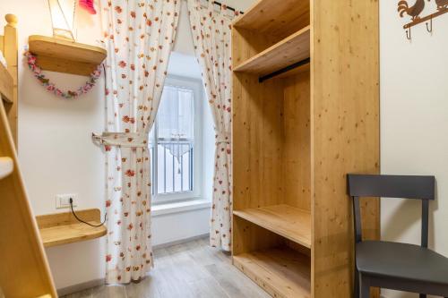 a room with a wooden closet and a window at L'antica corte apt Angelina in Levico Terme