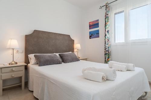 a bedroom with a large white bed with towels on it at Apartamento Cañada Honda Conil in Conil de la Frontera