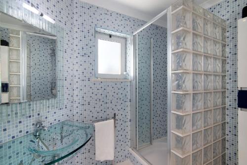 a bathroom with a glass shower and a tub at Pine Lodge in Vilamoura