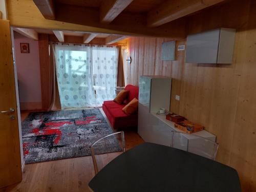 a living room with a red couch and a window at Monolocale Carfon in Canale dʼAgordo