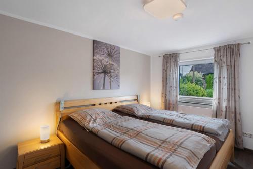a bedroom with two beds and a window at Ferienwohnung Selbecke in Kirchhundem