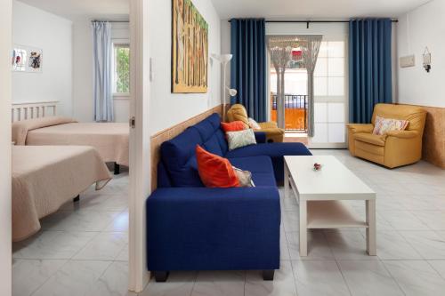 a living room with a blue couch and a table at Casa Santo front beach in Cala del Moral
