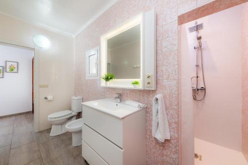 a bathroom with a sink and a toilet and a mirror at Casa Cantino in Santa Margalida