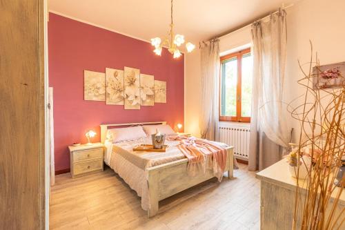 a bedroom with a bed and a red wall at Casa Vacanze Mongili - Il Moro in Chiusi