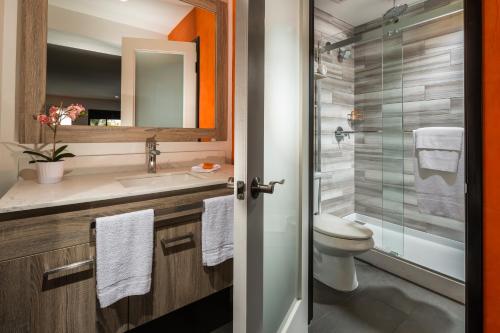 a bathroom with a toilet and a sink and a shower at Canoga Hotel at Warner Center in Canoga Park