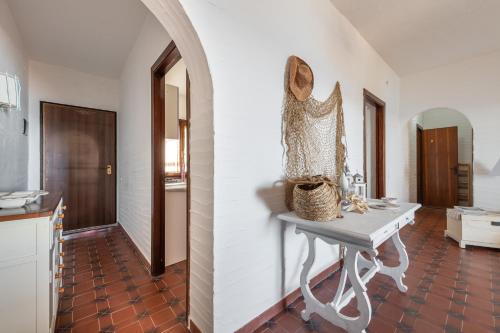 a white room with a table and a hallway at Casa Nicoleup in Porto Columbu - Perdʼe Sali