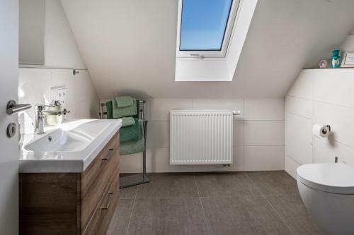 a bathroom with a sink and a toilet and a window at Fewo Schmidt in Bahlingen