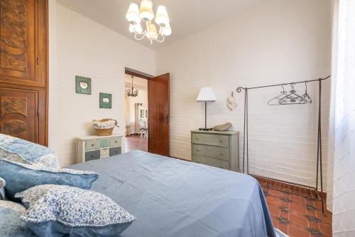 a bedroom with a blue bed and a dresser at Casa Nicoleup in Porto Columbu - Perdʼe Sali