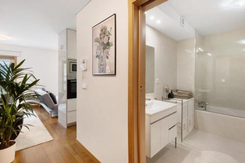 a white bathroom with a sink and a shower at Mary House in Matosinhos