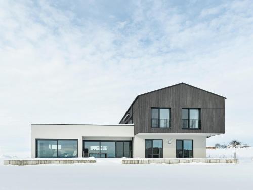 a black and white house in the snow at Chalet Am Ried in Bad Wurzach