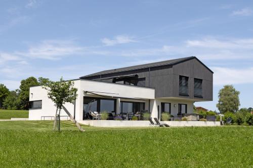 a modern house with a black and white facade at Chalet Am Ried in Bad Wurzach