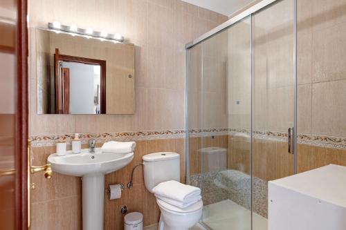 a bathroom with a toilet and a sink and a shower at Casa Candido in Playa Honda