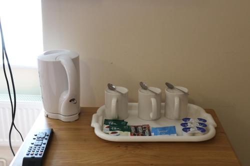 a table with a coffee maker and a remote control at Acorn Lodge Guest House in Gosport