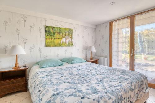 a bedroom with a bed and a window at Le Clos Rilda en Bounet in Villefranche-de-Lauragais