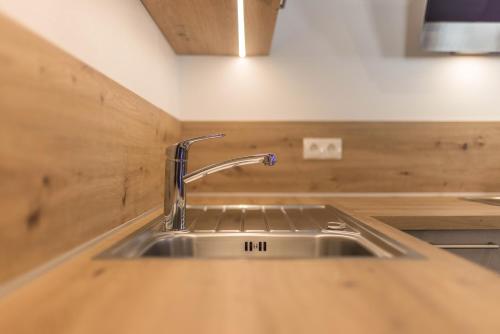 a kitchen sink with a faucet on a counter at Lechnerhof Fane Alm in Valles